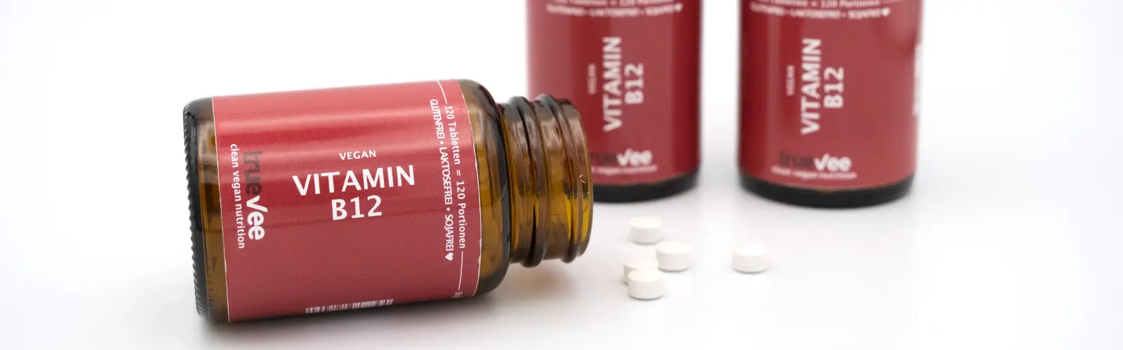 Vitamin B12 Tabletten von True Vee, Dose liegt offen auf der Zeit und Tabletten daneben